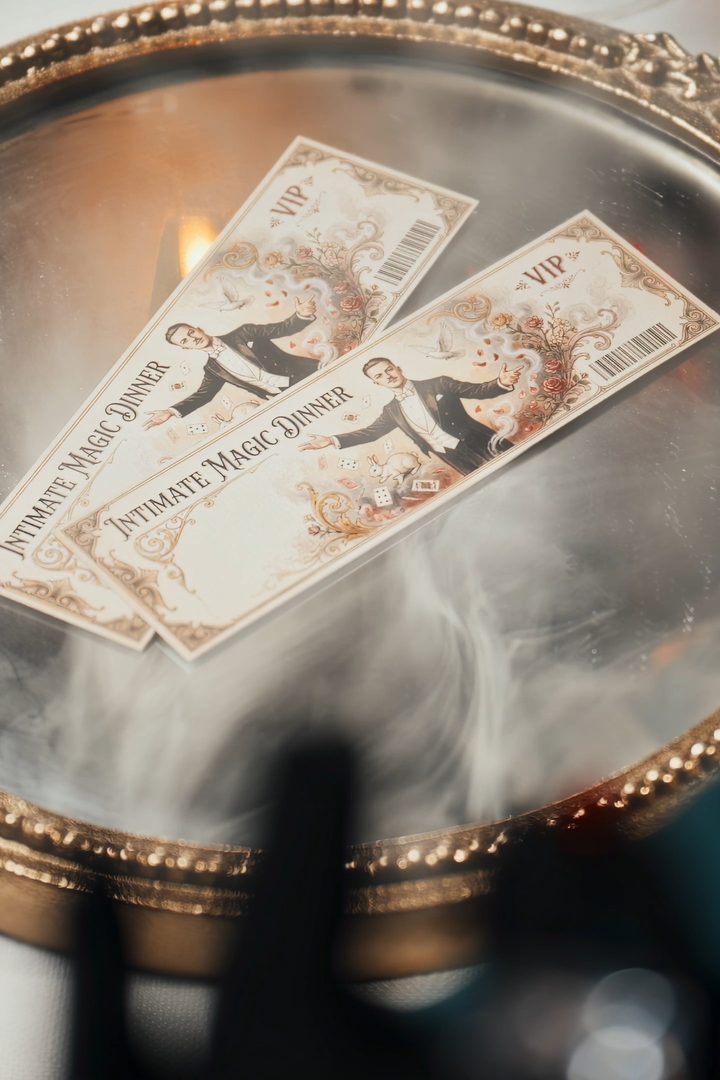 Two vintage VIP tickets reading Intimate Magic Dinner on a gilded tray in drifting smoke