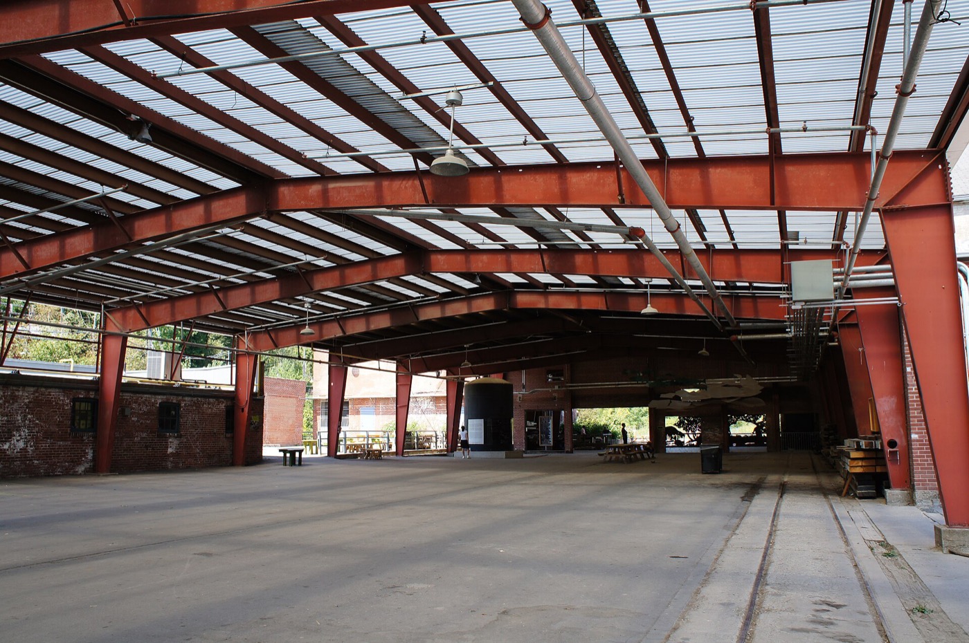 Evergreen Brick Works: a large open steel-framed hall with red roof trusses and a concrete floor