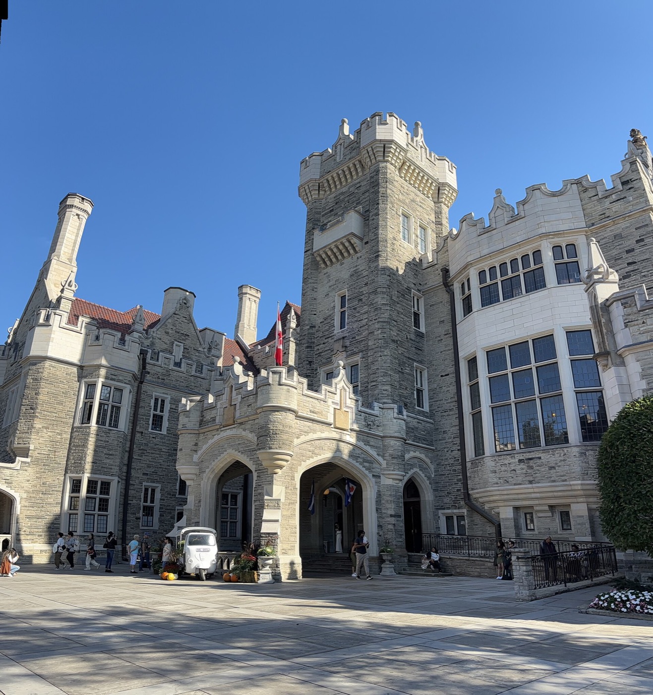 Casa Loma castle in Toronto: grey stone tower, arched entrance and a glass-walled wing around a courtyard