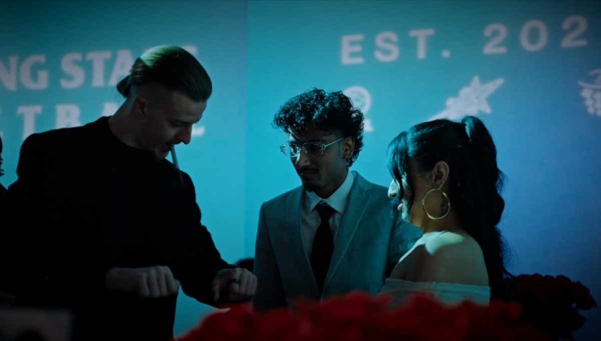 Roman Royss performing for a couple at a table with red roses